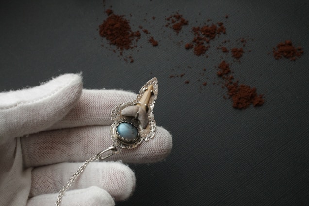 Portrait of Chritien Oldbury examining a sparkling gemstone under a jeweler's loupe.