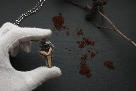 Close-up of a custom corrupted eye pendant glowing softly on a velvet cushion.