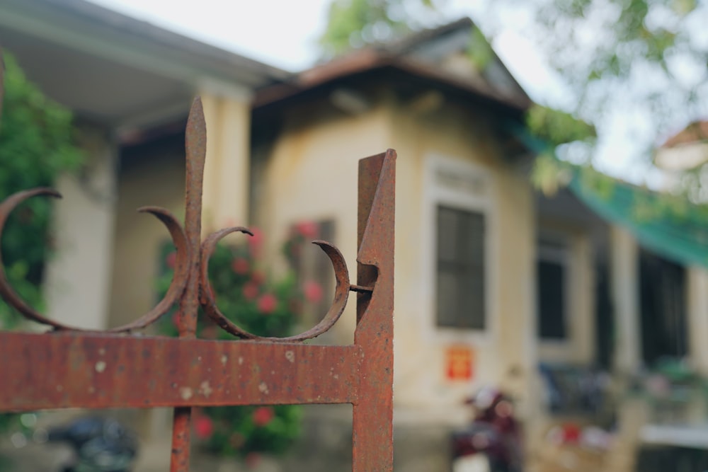 a close up of a metal fence in front of a house