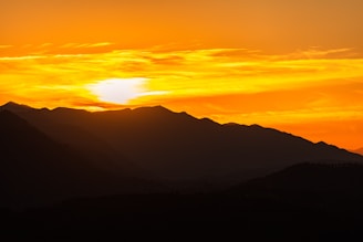 A stunning landscape photograph capturing a serene sunset over mountains.
