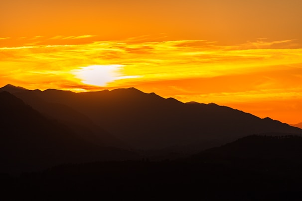 A stunning landscape photograph capturing a serene sunset over mountains.