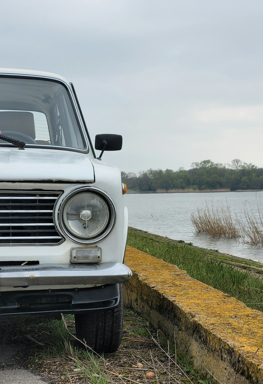 a white car parked next to a body of water