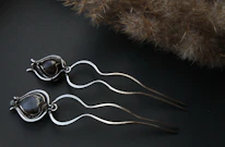 Close-up of a gold-accented hair accessory resting on a black velvet surface.