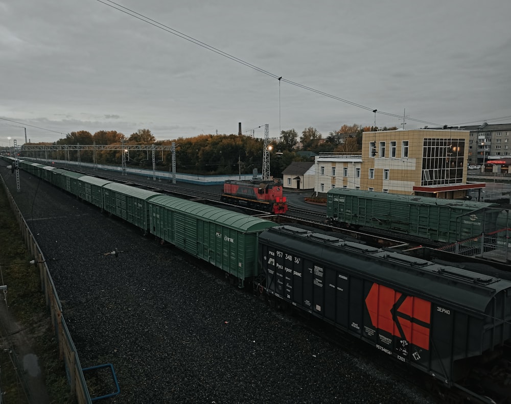 a train traveling down train tracks next to a tall building