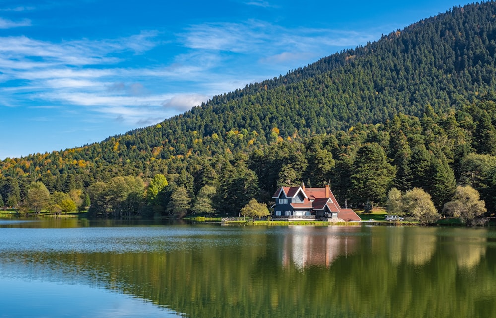 a house sitting on top of a lake next to a forest