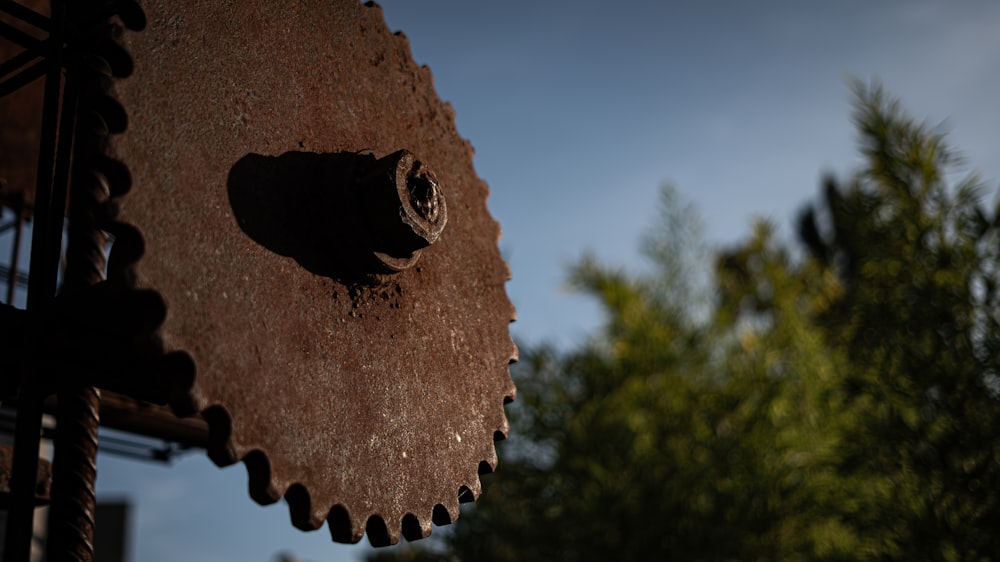 a close up of a clock face with trees in the background