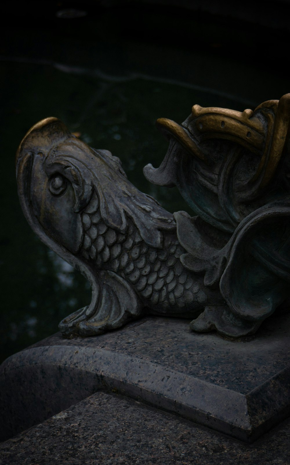 eine Statue eines Fisches auf einem Steinblock