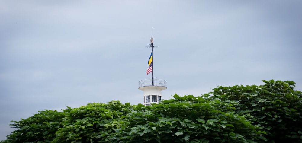a white tower with a flag on top of it