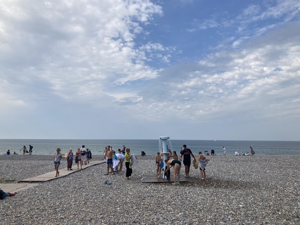 a group of people standing on top of a sandy beach