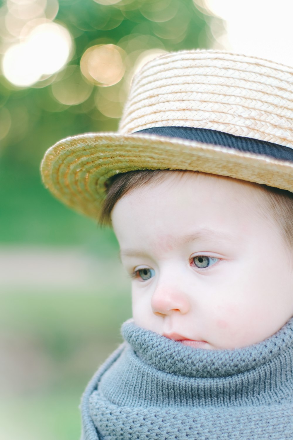 a little boy wearing a hat and a sweater