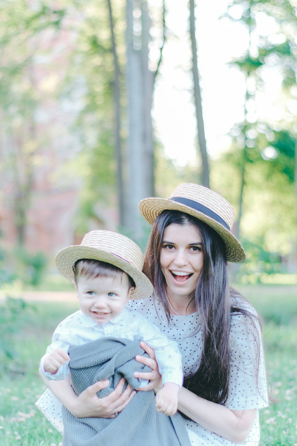 a woman holding a baby wearing a hat