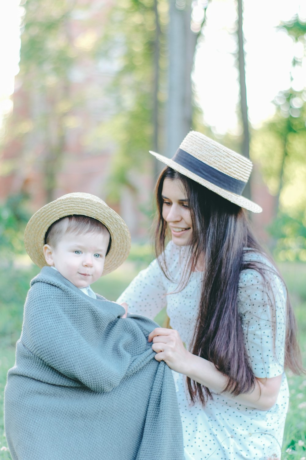 a woman holding a child wrapped in a blanket