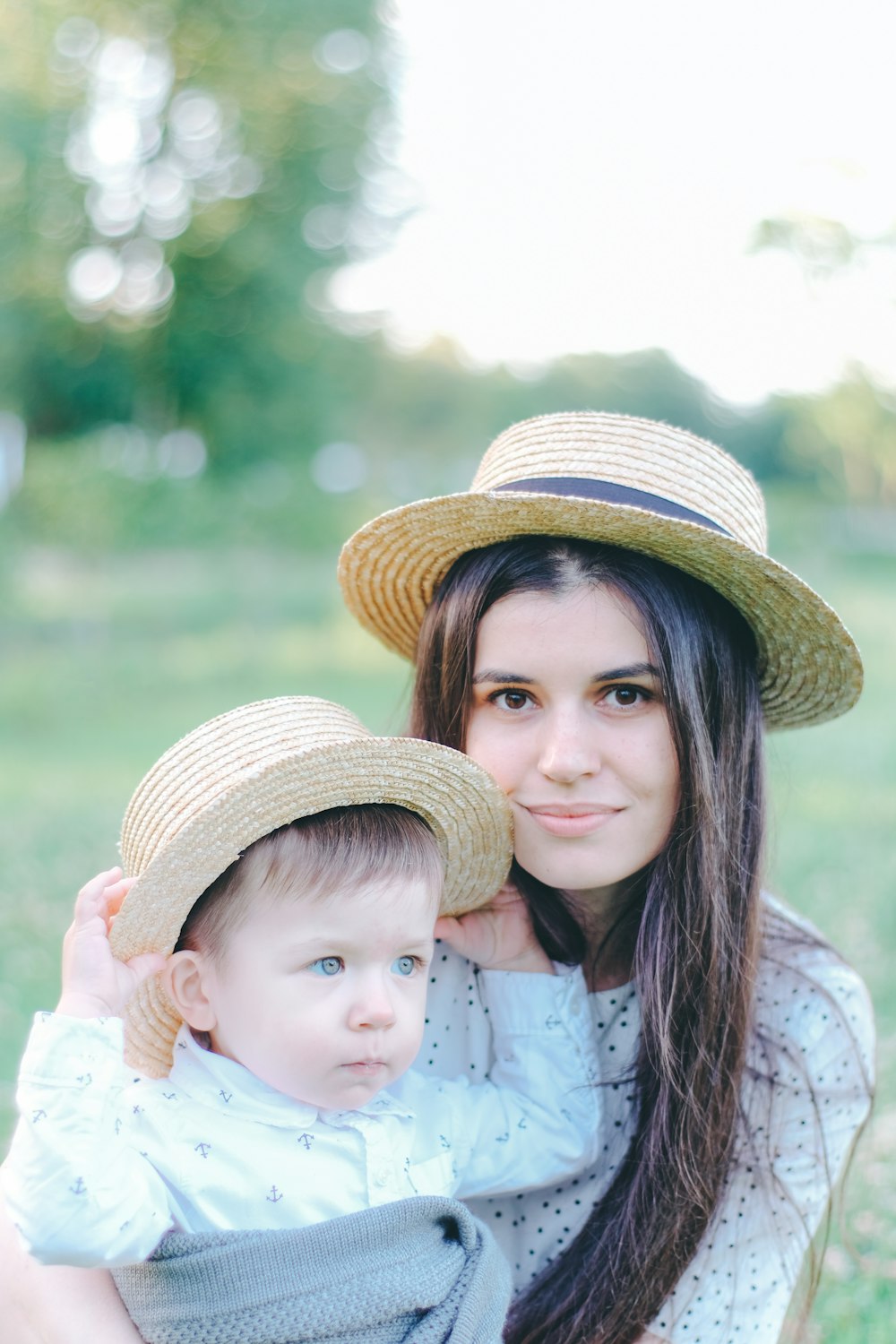 a woman holding a baby wearing a hat