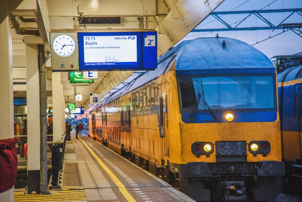 a yellow train pulling into a train station