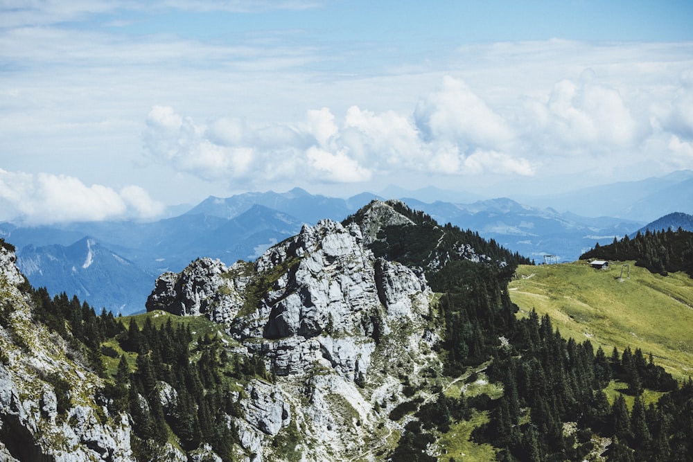 uma vista de uma cordilheira com árvores e montanhas ao fundo