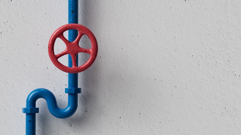 a red and blue hook on a white wall