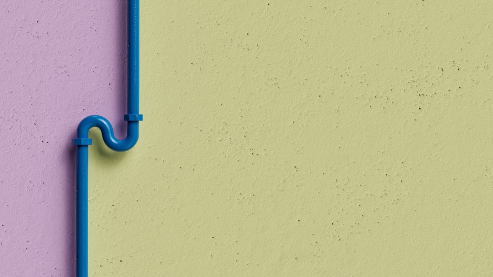 a blue pipe on a yellow and purple wall