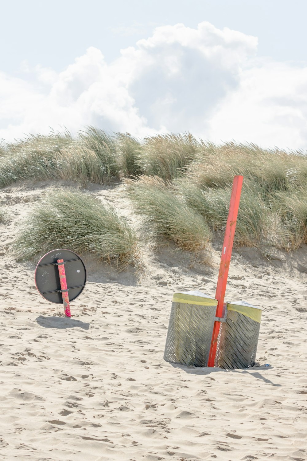 a beach area with sand, grass, and a frisbee