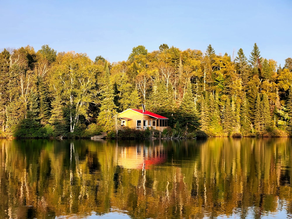 a house sitting on top of a lake surrounded by trees