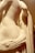 A close-up of a marble sculpture depicting a partially draped human figure with detailed carving. The smooth curves and folds of the material showcase the craftsmanship and evoke a classical aesthetic.