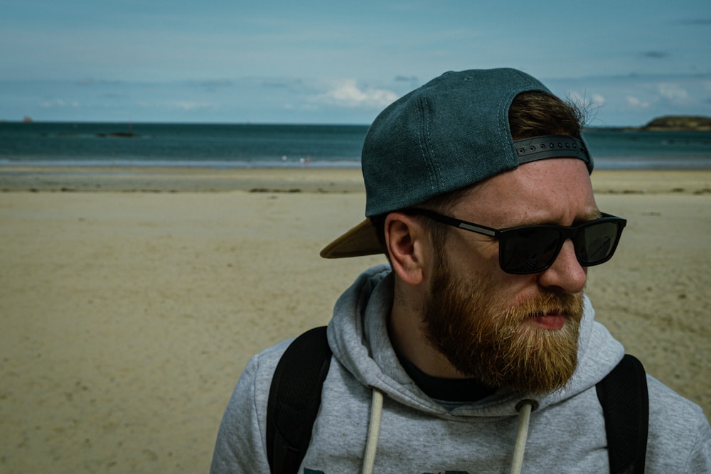 a man with a beard wearing a hat and sunglasses