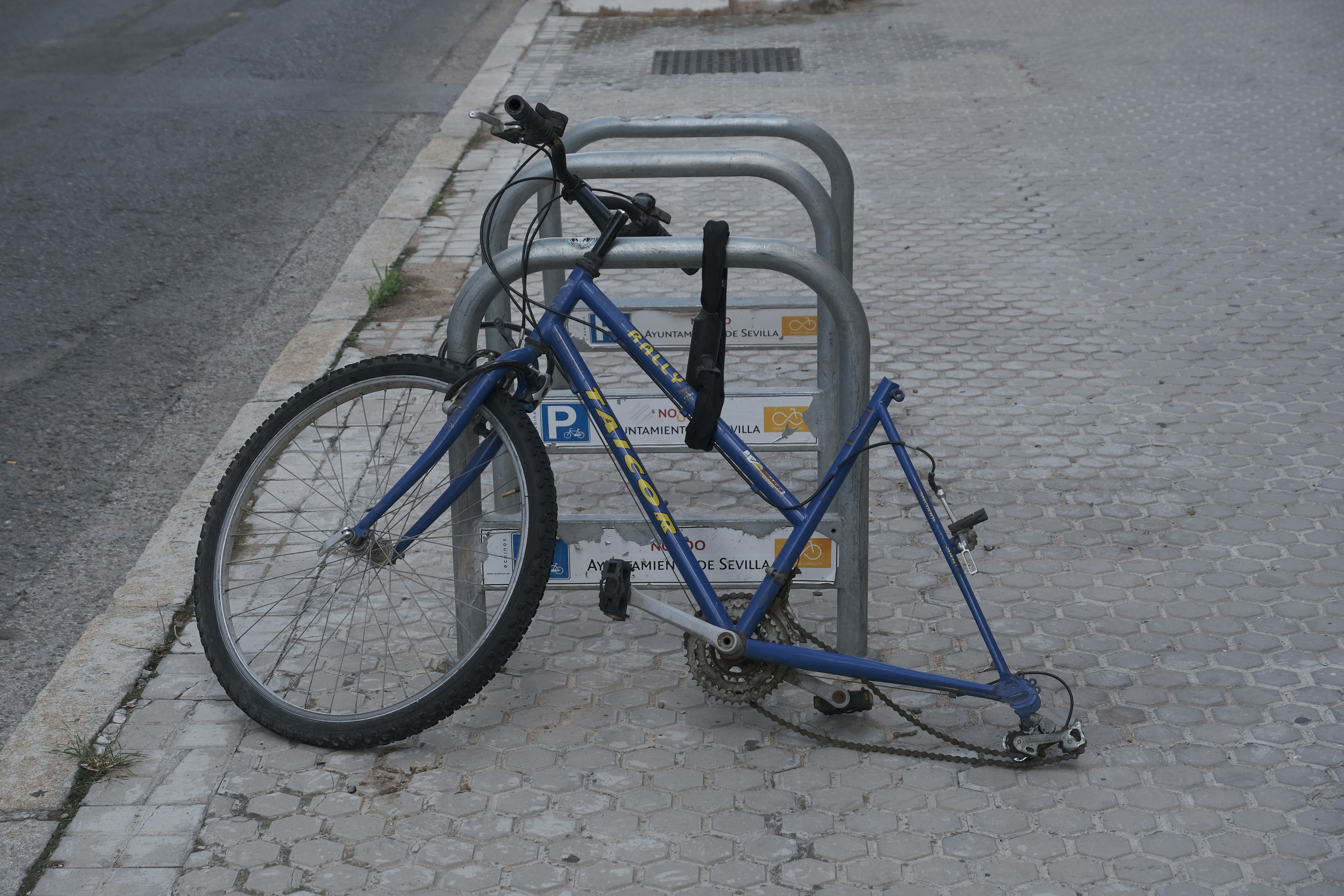 A bicycle locked to a bike rack on the side of the road photo – Free ...
