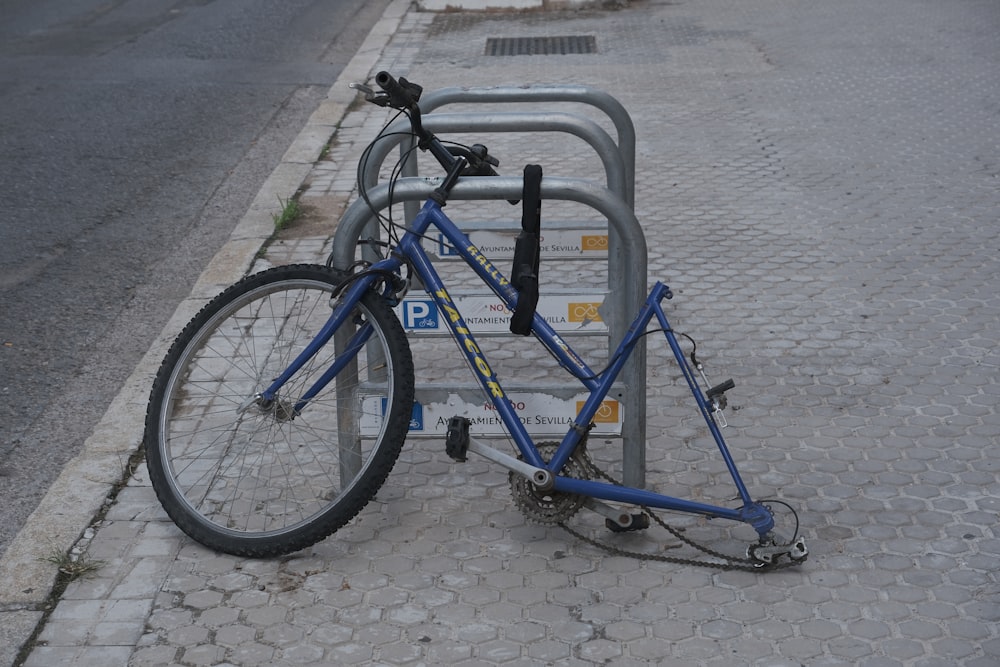 a bicycle locked to a bike rack on the side of the road