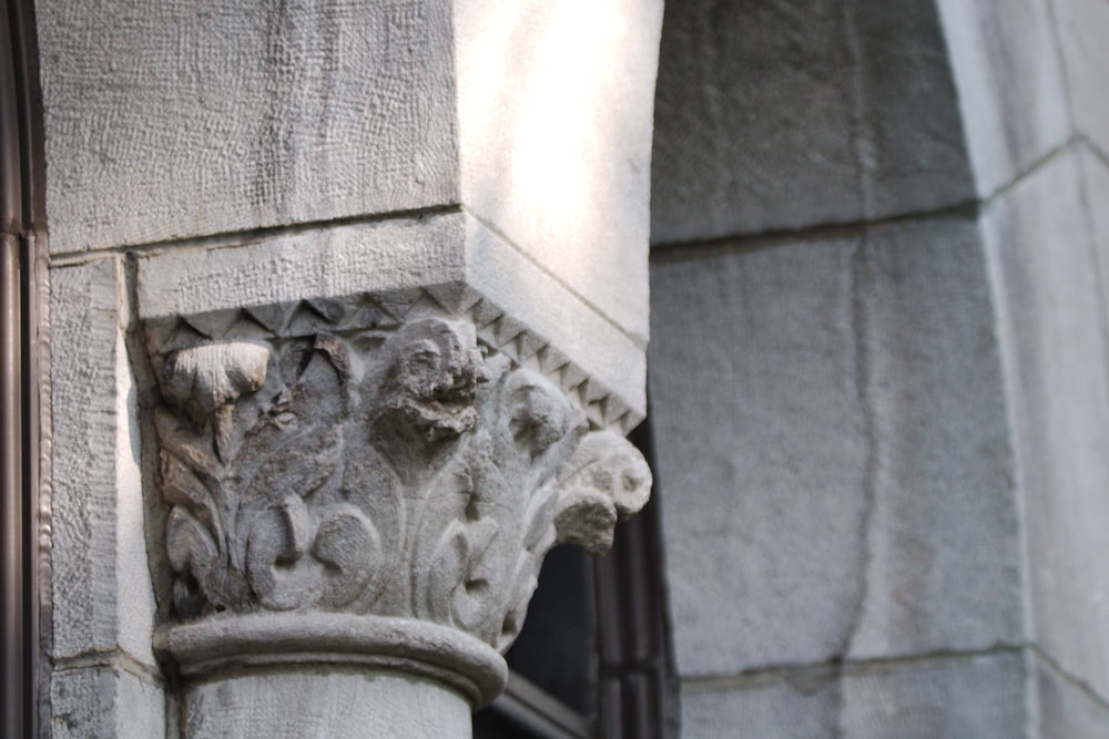 a close up of a stone column with a window in the background