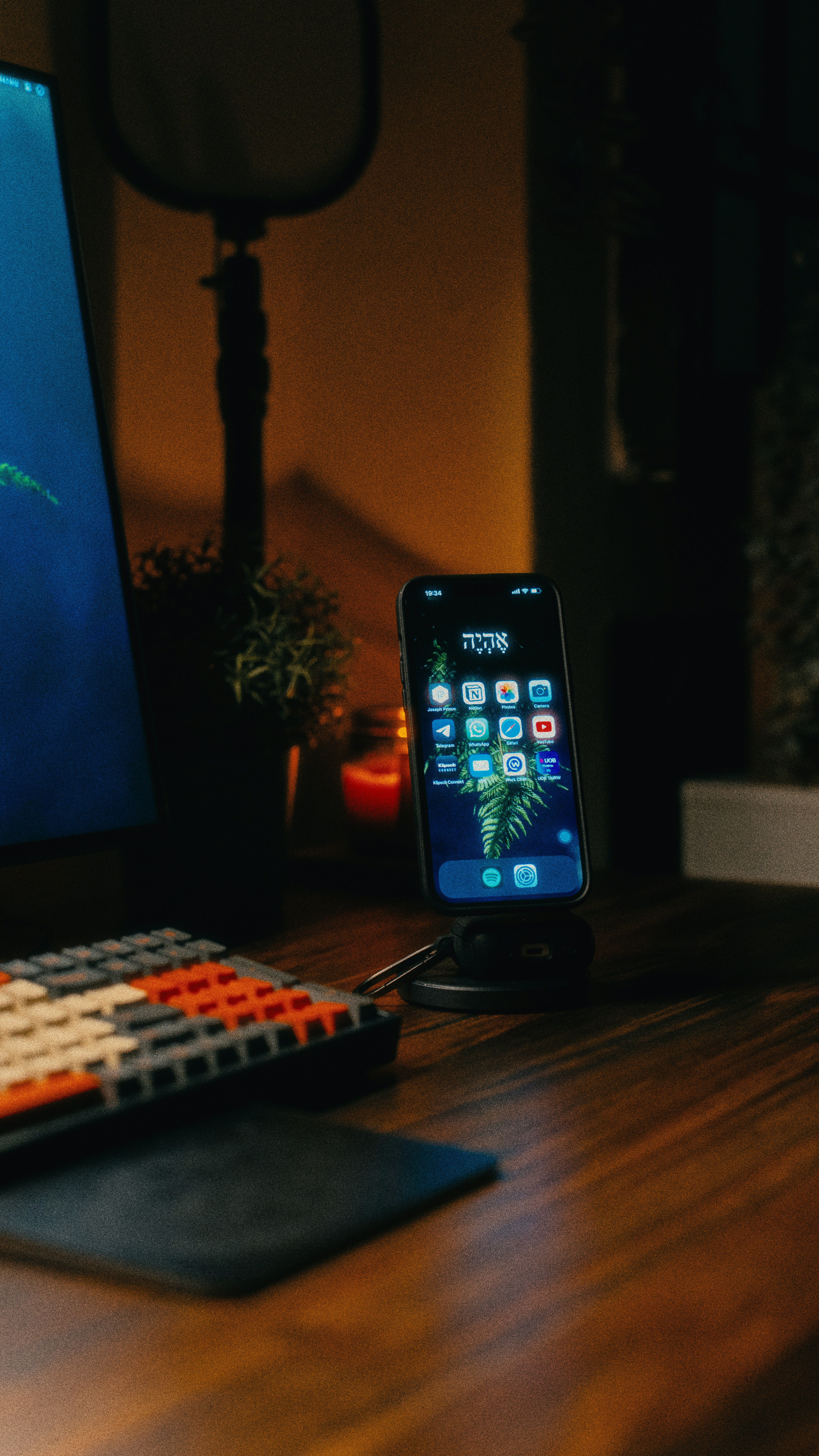 ponsel yang duduk di atas meja di sebelah keyboard