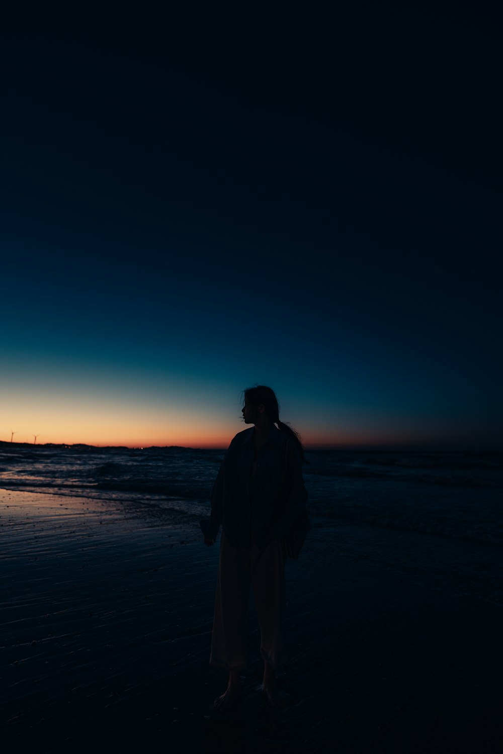 a person standing on a beach at night