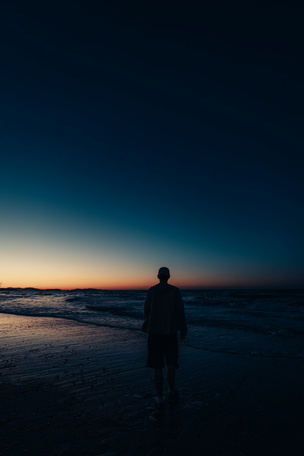 a person standing on a beach at night