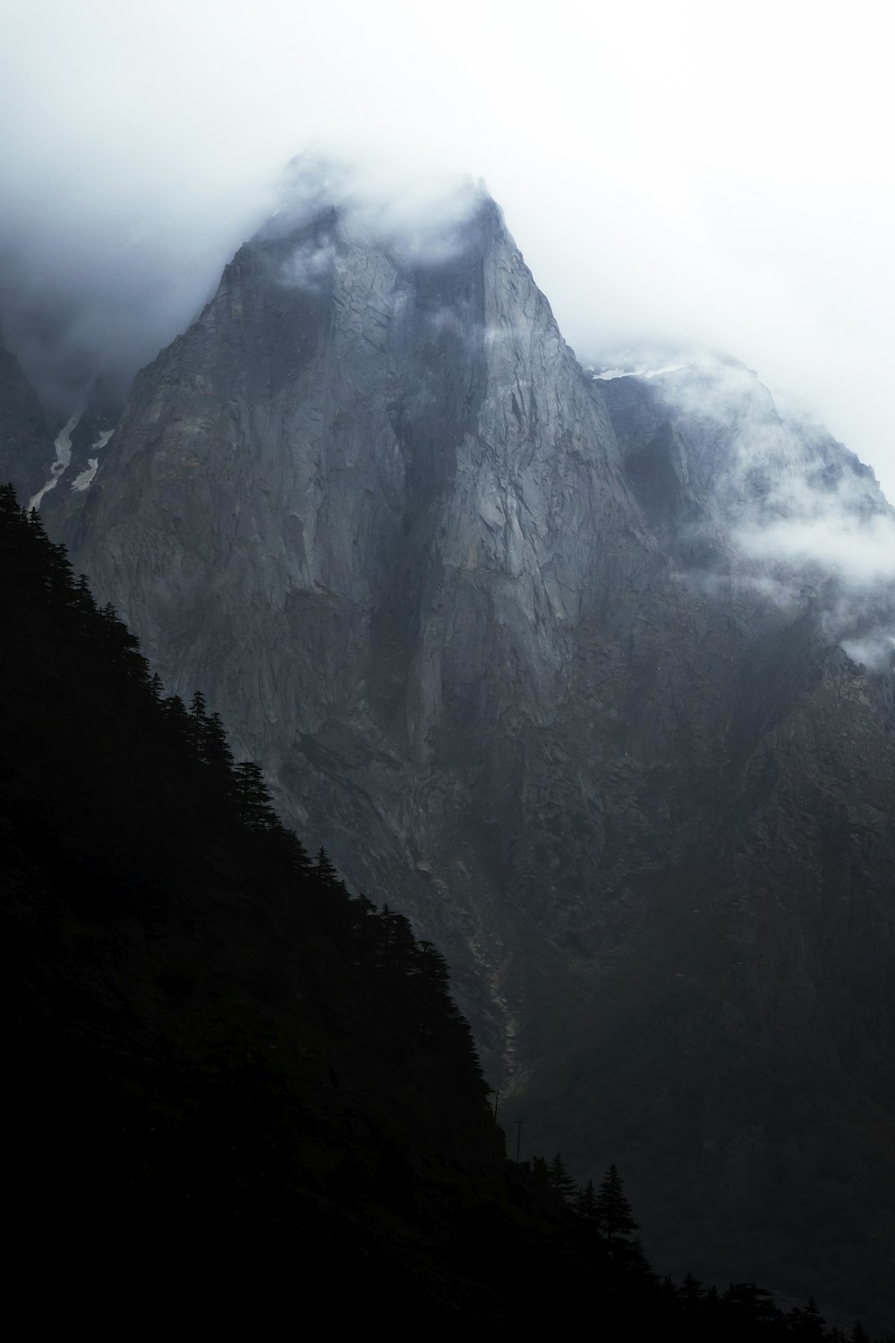 a very tall mountain covered in clouds and fog