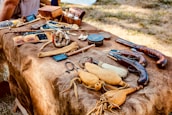Rustic hunting gear neatly arranged on a wooden table, reflecting tradition and care.