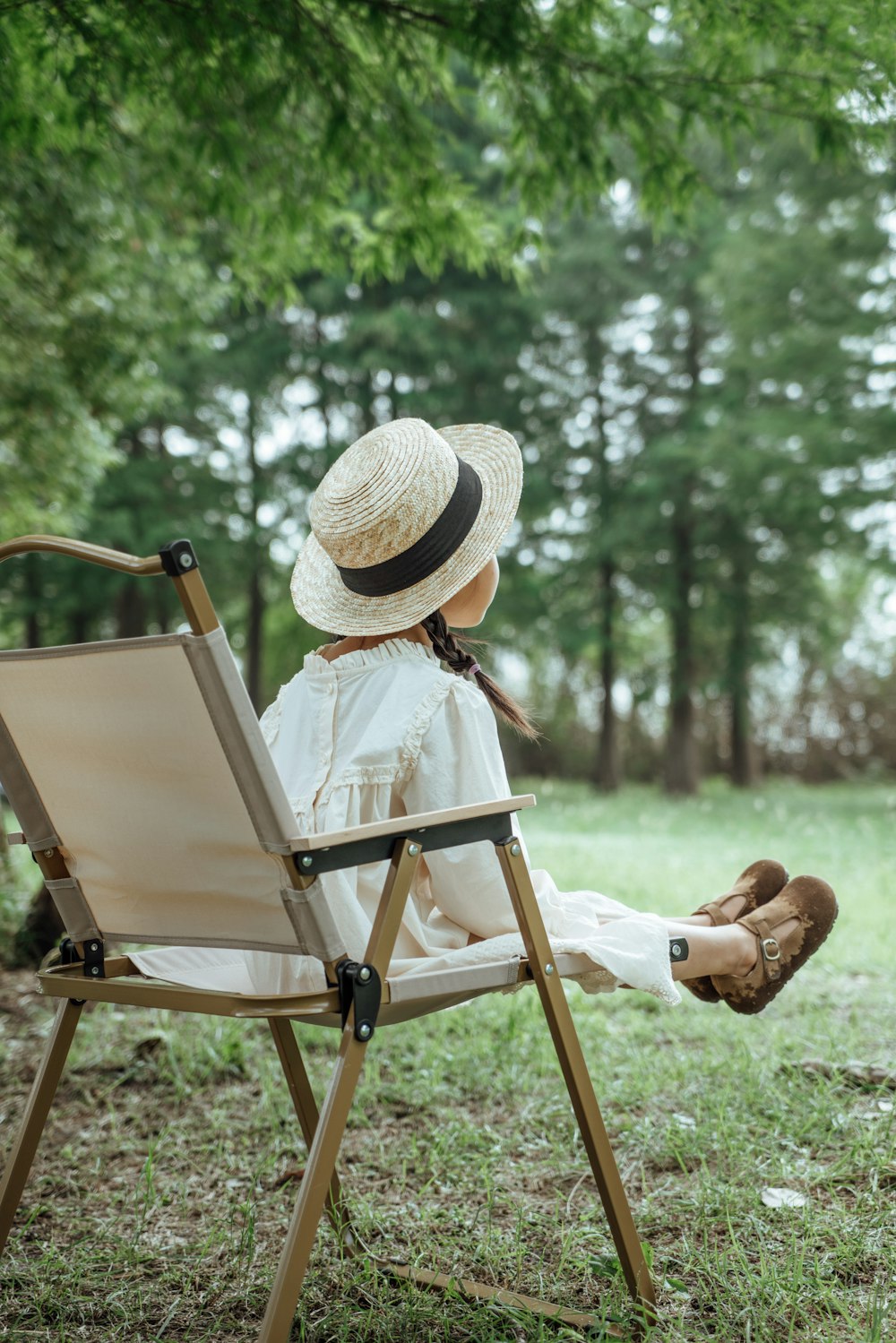 a little girl sitting in a chair with a hat on