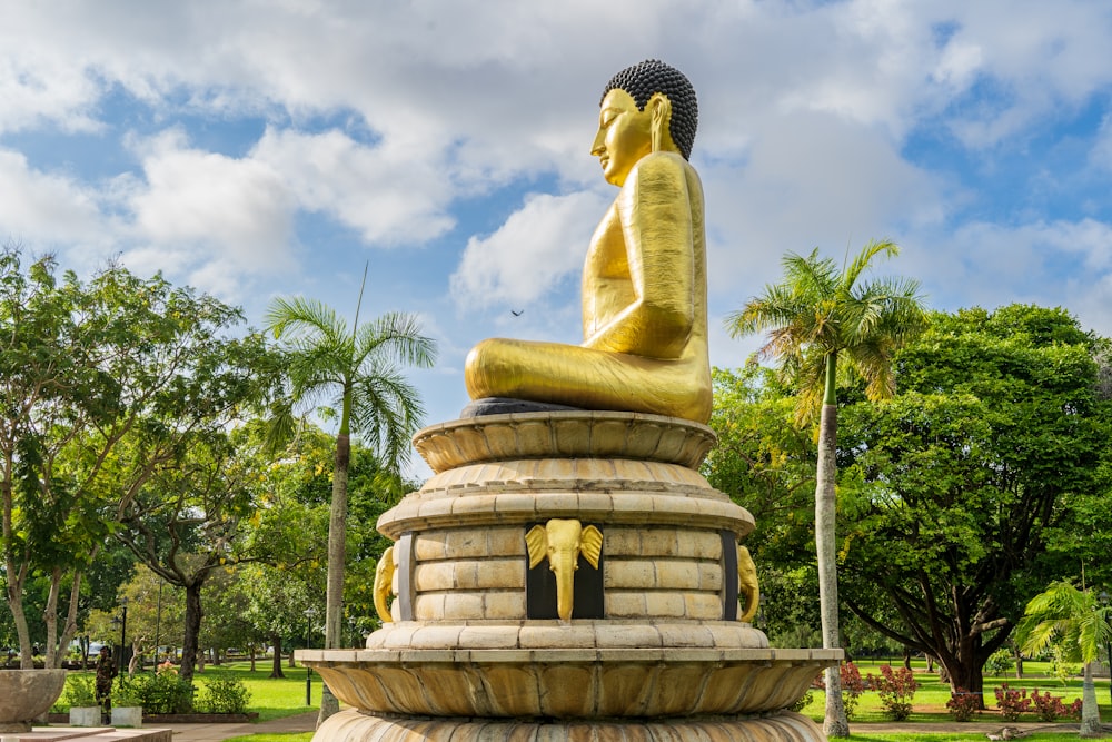 a golden buddha statue sitting on top of a fountain