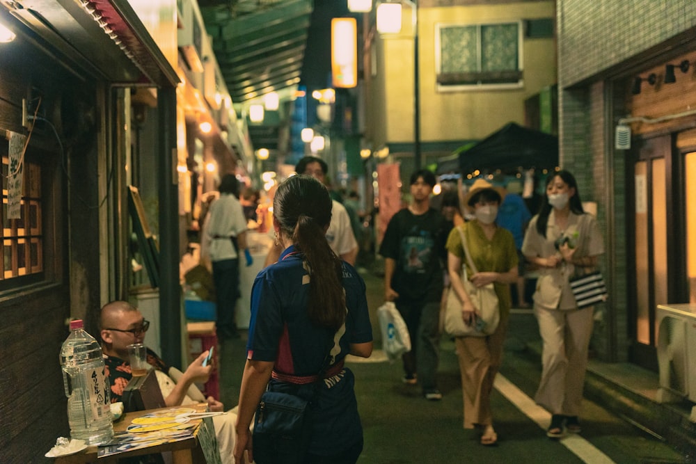 a group of people walking down a street at night