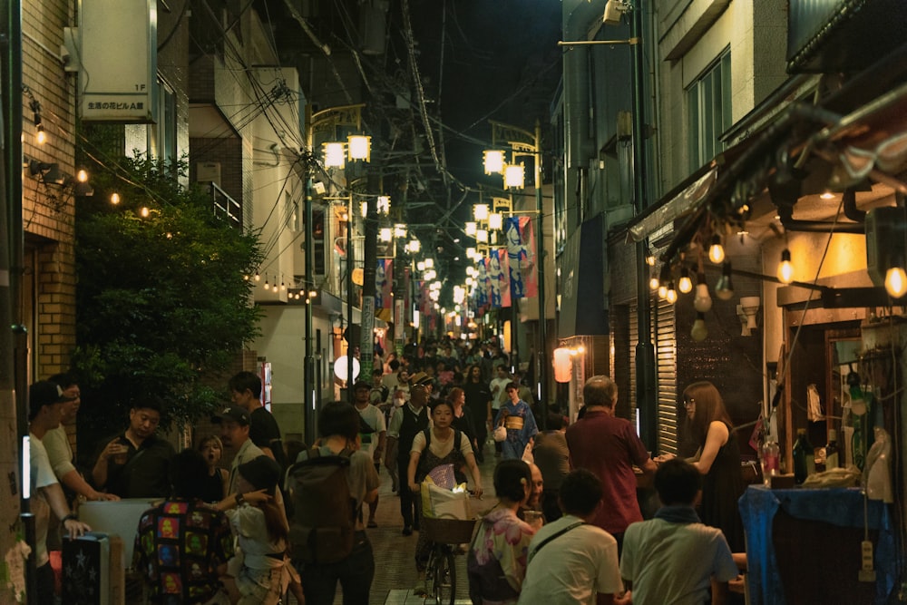 a group of people walking down a street next to tall buildings