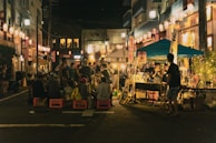A bustling Asian night market glowing with lanterns and filled with street food stalls.