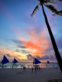 A vibrant beach scene with travelers enjoying a sunset.