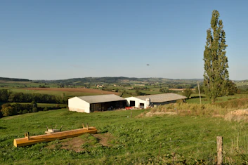 a farm with a barn and two barns in the background