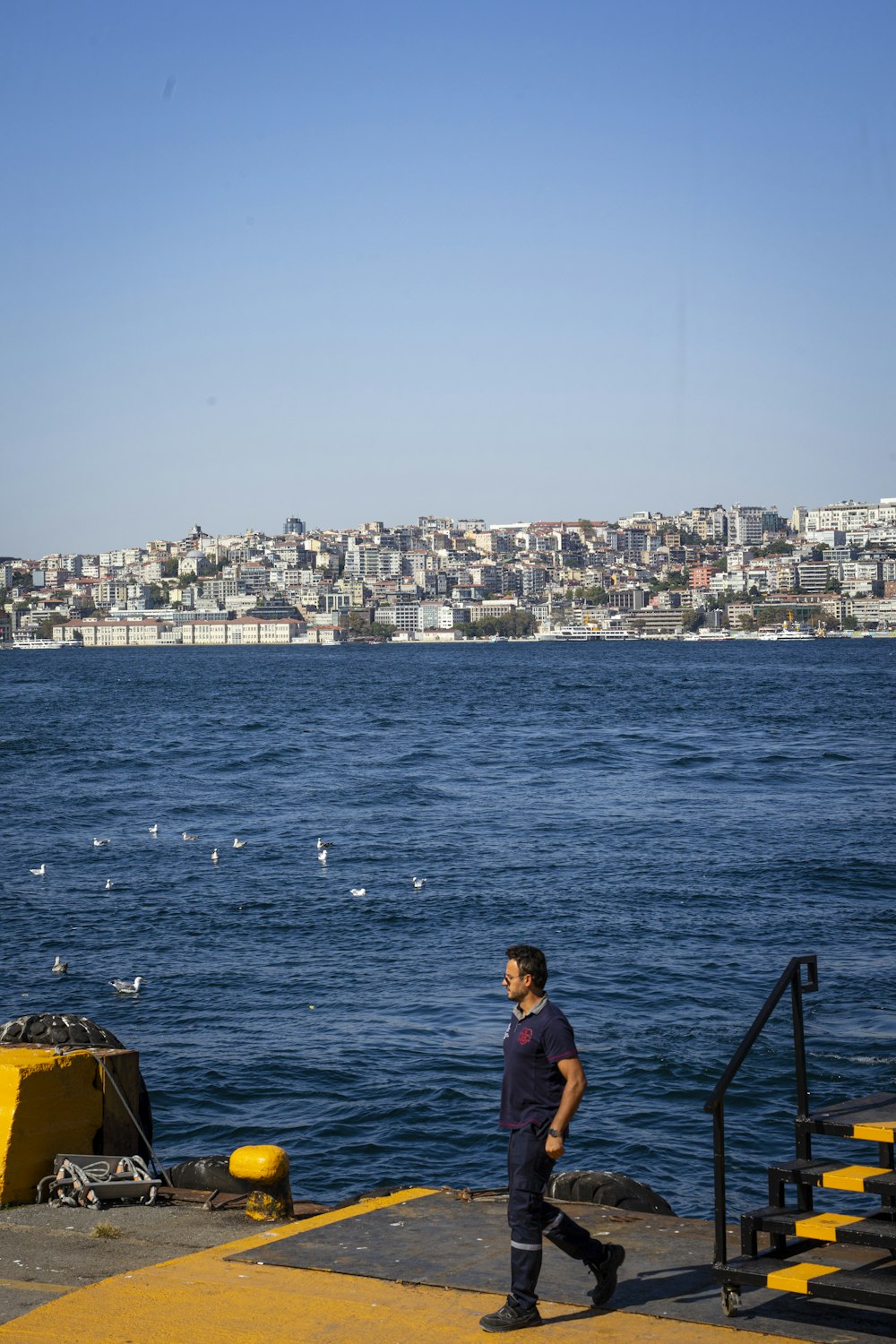 a man standing on a pier next to the ocean