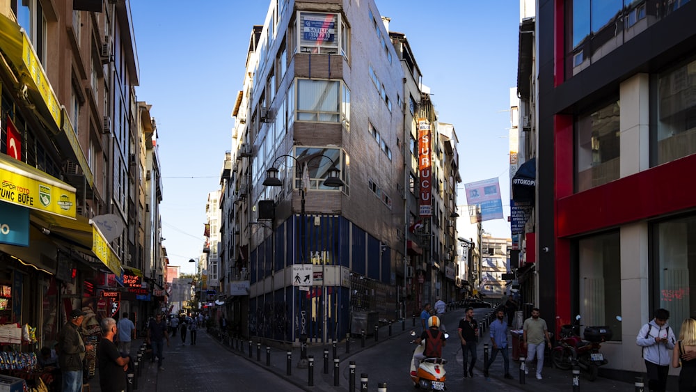 a group of people walking down a street next to tall buildings