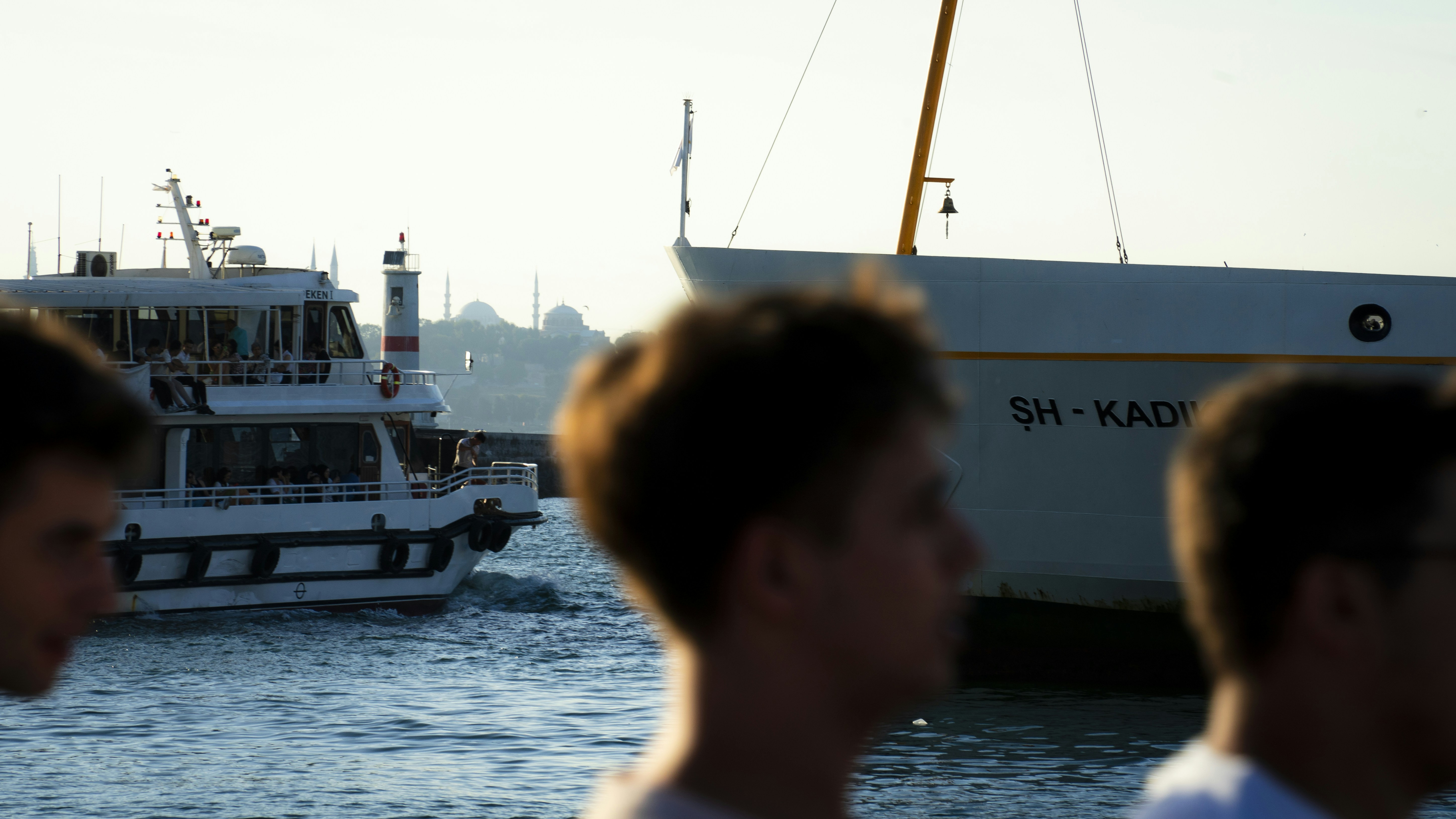 Zwei Männer beobachten ein vorbeifahrendes Boot