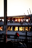 Guests celebrating on deck with golden sunset lighting casting warm glows over their joyful faces.