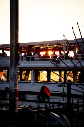 Guests celebrating on deck with golden sunset lighting casting warm glows over their joyful faces.