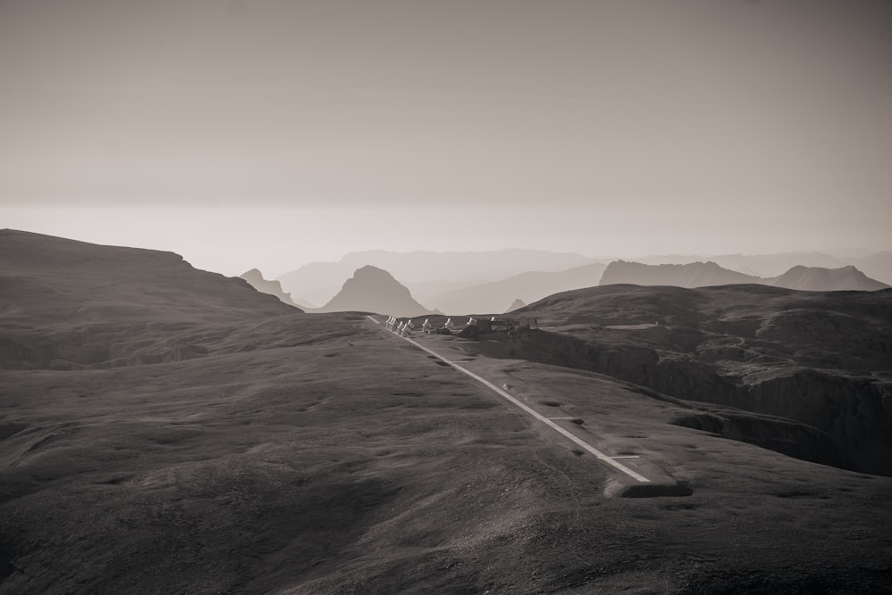 Une photo en noir et blanc d’une route dans les montagnes