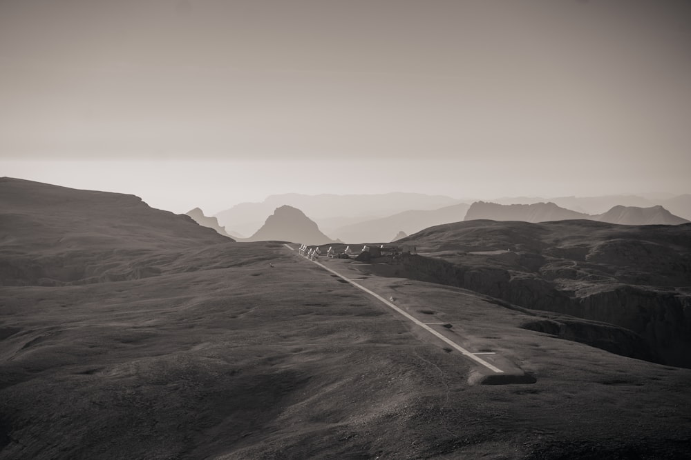 a black and white photo of a road in the mountains