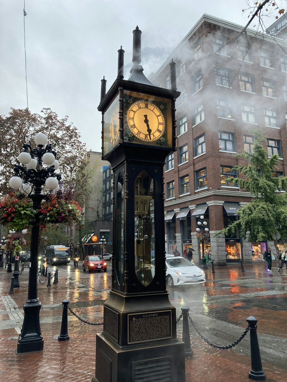a clock tower on a city street in the rain