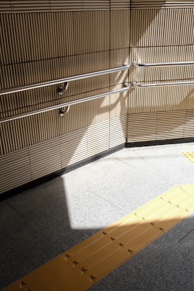 A tactile yellow accessibility floor guiding visitors through a photo exhibition space.