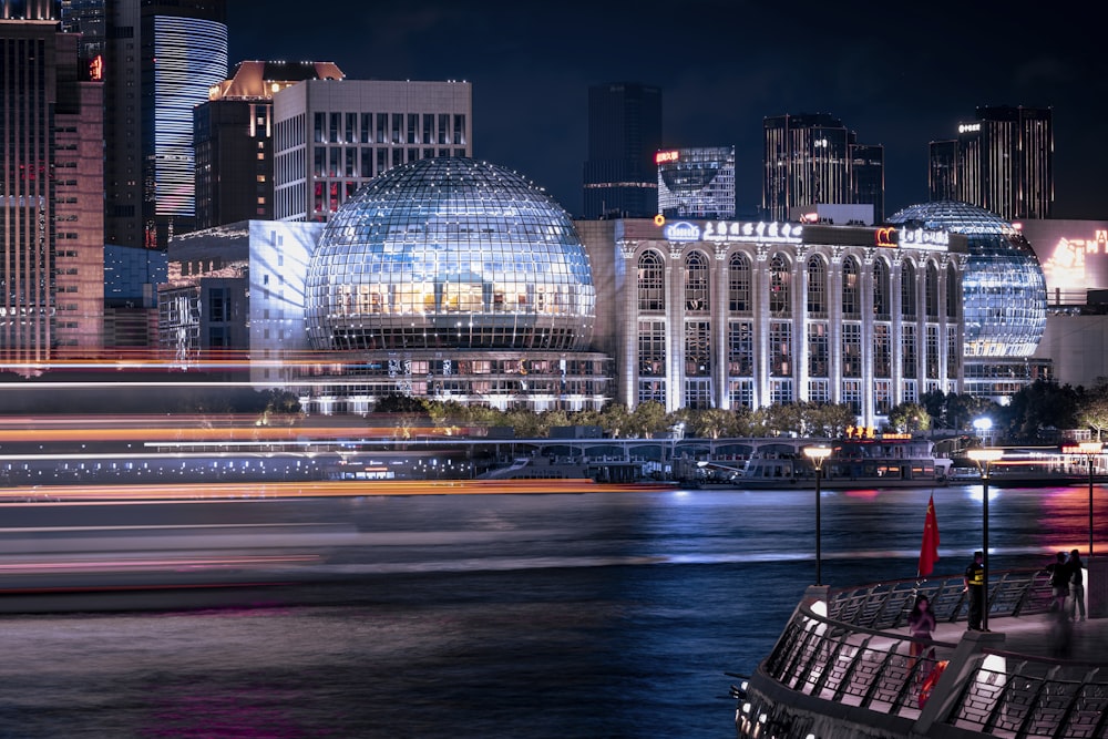 a city skyline at night with a boat in the foreground